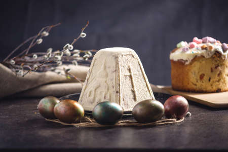 Card with traditional desserts and colorful eggs in rustic style on a dark background. Concept happy Easterの写真素材