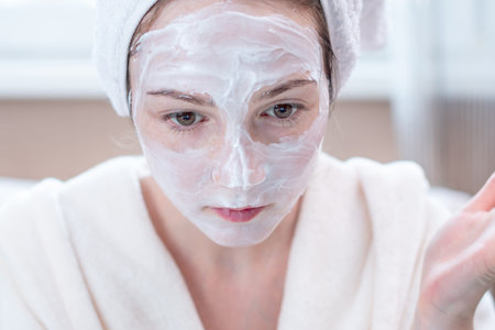 Beautiful happy young woman with natural cosmetic mask on her face. Concept skin care and Spa treatments at homeの写真素材