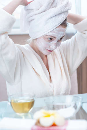 Beautiful happy young woman with natural cosmetic mask on her face. Concept skin care and Spa treatments at homeの写真素材