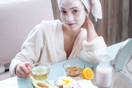 Beautiful happy young woman with natural cosmetic mask on her face. Concept skin care and Spa treatments at homeの写真素材