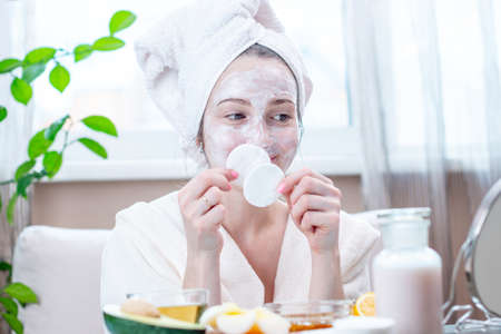 Beautiful happy young woman with natural cosmetic mask on her face. Concept skin care and Spa treatments at homeの写真素材