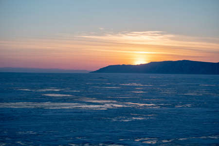 Beautiful view of the sunset landscape on the snowy lake Baikal in winter. Nature and travelの写真素材