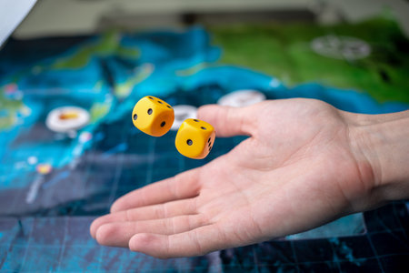 The hand throws yellow dice on the playing field. Luck and excitement. The concept Board games