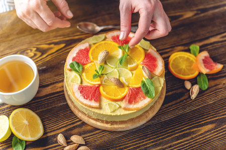 Raw citrus cake with grapefruit, orange, lime and lemon with nuts and mint. Cooking at home healthy summer vegan dessert with vegetable ingredientsの写真素材