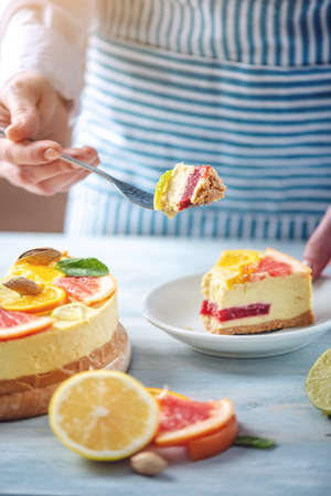 A piece of raw citrus cake with grapefruit, orange, lime and lemon with nuts and mint. Cooking at home healthy summer vegan dessertの写真素材