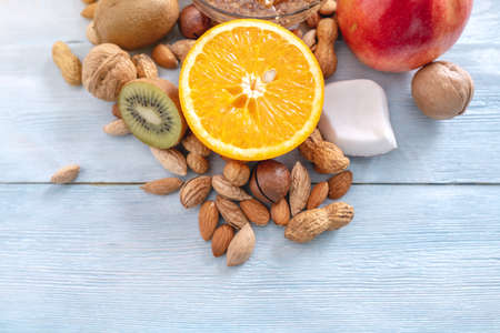Healthy vegan raw foods on blue wooden background. Fruits and nuts with honey on the table. Natural organic sweet dessert. Place for textの写真素材