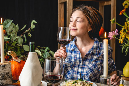 Holiday weekend cute dinner with red wine and pasta. Autumn set and yellow flowers on a wooden table...