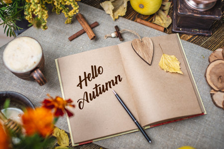 Autumn set of yellow leaves and flowers. Notebook with open pages on the table. Space for text. Top...