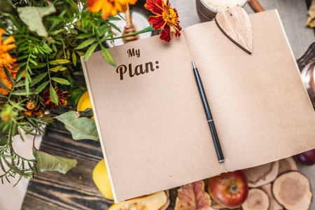 Autumn set of yellow leaves and flowers. Notebook with open pages on the table. Space for text. Top...