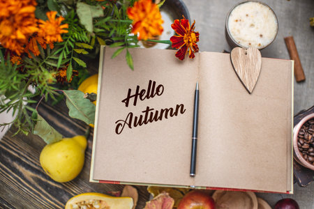 Autumn set of yellow leaves and flowers. Notebook with open pages on the table. Space for text. Top...