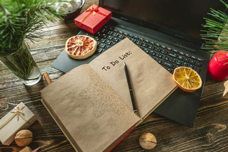 Notepad with open pages and pen on wooden background. Planning goals for the new year on Christmas eve. Space for text. The view from the topの写真素材