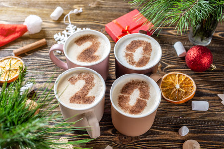 Card with numbers 2020 for New year and Christmas. Cup of coffee with figures on milk foam on wooden...
