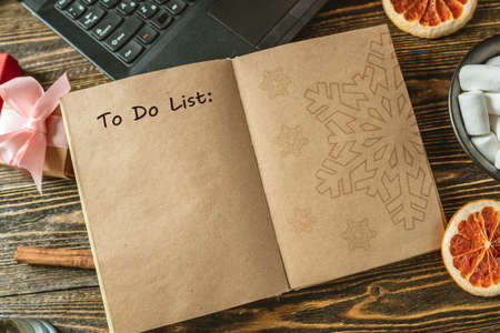 Notepad with open pages and pen on wooden background. Planning goals for the new year on Christmas eve. Space for text. The view from the topの写真素材