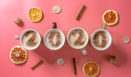 Card with numbers 2020 for New year and Christmas. Cup of coffee with figures on milk foam on pink background. The view from the top. Flat layの写真素材