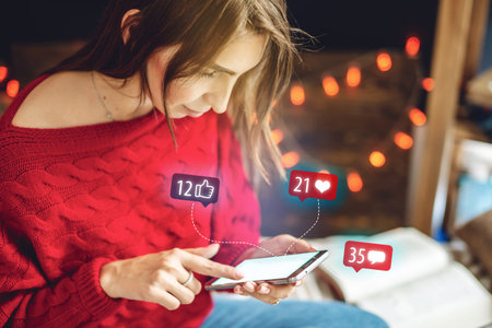 Young beautiful woman using her phone spends time on social looking at the display. Girl is reading...