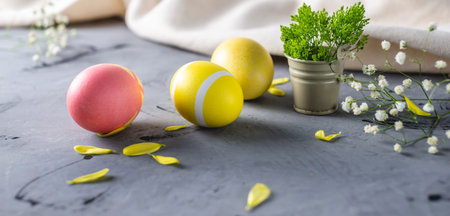Bright colorful Easter eggs with spring flowers on a gray background. Festive spring Easter card.