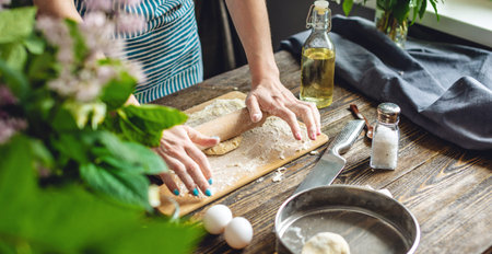 The woman is rolling out fresh dough for making pasta in a cozy atmosphere. Concept of cooking tasty...