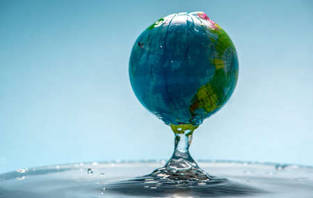 Planet Earth in the form of a globe in transparent water with splashes. Concept of eco friendly behavior and keeping water cleanの写真素材