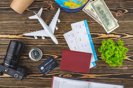 Documents, plane tickets and other travel supplies on a wooden background. Top view.の写真素材