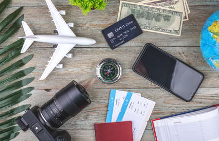 Documents, plane tickets and other travel supplies on a wooden background. Top view.の写真素材