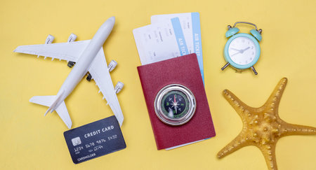 Layout of accessories for vacation and travel on a yellow background. Vacation and ticket booking concept.の写真素材