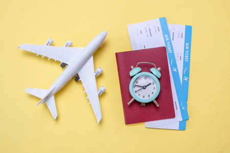 Layout of accessories for vacation and travel. Air tickets, money and documents on a yellow background.の写真素材