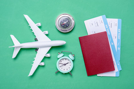 Plane, airline tickets and passport on a green background with a top view. Concept of travel and buying air tickets.の写真素材