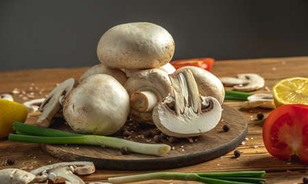 Mushrooms, vegetables, lemon and spices on a wooden table. Concept of ingredients for cooking a delicious dish.の写真素材