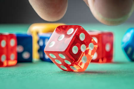 The hand is throwing red dice on the green table. The concept of a casino and a lucky chance to winの写真素材