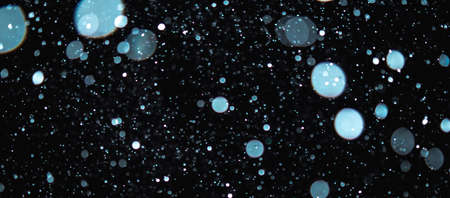 Blurred snowflakes on a dark background. Overlay image for snowfall effect.の写真素材