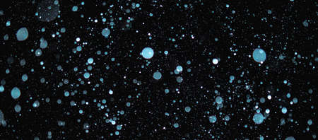 Blurred snowflakes on a dark background. Overlay image for snowfall effect.の写真素材