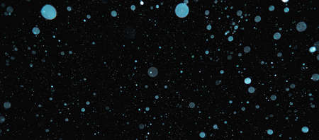 Blurred snowflakes on a dark background. Overlay image for snowfall effect.の写真素材
