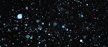 Blurred snowflakes on a dark background. Overlay image for snowfall effect.の写真素材