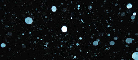 Blurred snowflakes on a dark background. Overlay image for snowfall effect.の写真素材