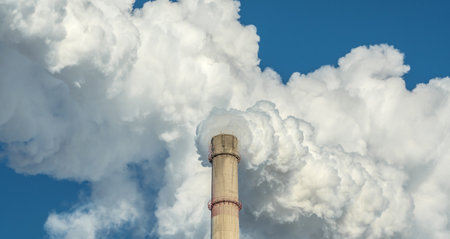 Powerful industrial factory chimney is smoking and emitting carbon dioxide into the environment. Concept of air pollution and the problem of global warmingの写真素材