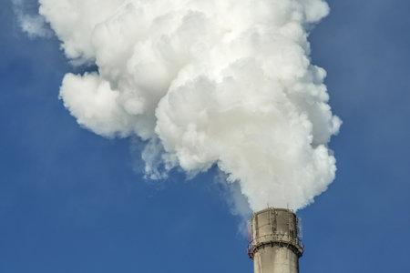 Powerful industrial factory chimney is smoking and emitting carbon dioxide into the environment. Concept of air pollution and the problem of global warmingの写真素材