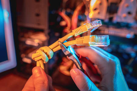 Cutting the Internet cable tied into a knot with wire cutters. The concept of disconnecting the Internet and restricting access to resourcesの写真素材