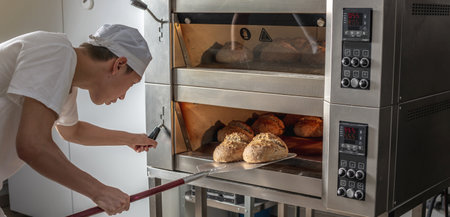 The baker is a man in the process of baking bread. Production of bakery products as a small business.の写真素材
