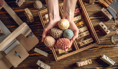 A woman soap maker holds soap in her hands in the form of colorful coniferous cones. An interesting gift for New Year's holidays and Christmas. Eco-friendly natural handmade cosmetics.の写真素材