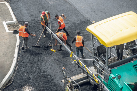 Workers lay a new asphalt coating using hot bitumen. Work of heavy machinery and paver. The view from the topの写真素材