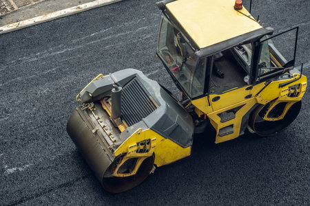 Workers lay a new asphalt coating using hot bitumen. Work of heavy machinery and paver. The view from the topの写真素材