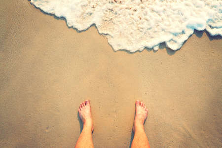 Standing on the beach with wave comingの写真素材