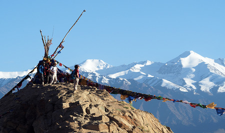 Happy unidentified tourists stand on top of the mountain with mantra flags at Namgyal Gompa in Leh, Indiaの写真素材