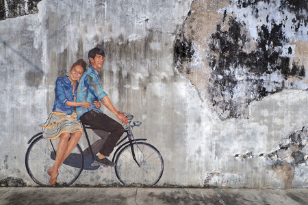 Malaysia - AUGUST 17 2017: Street art boy and girld riding bicycle painted on old texture wall photography with copy text space, Georgetown Penang Malaysiaのeditorial素材