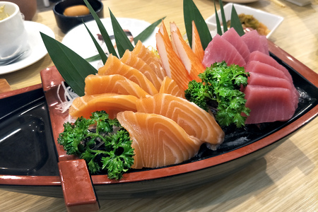 Japanese food - Sashimi Salmon and tuna served on boat in Japanese restaurant environmentの写真素材