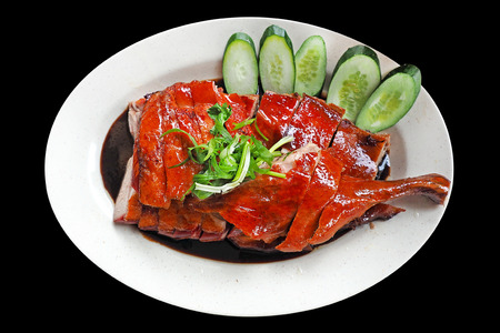 Chinese Roasted duck cutted and served on white dish topped with black gravy herbal sauce isolated on black background with clipping path
の写真素材