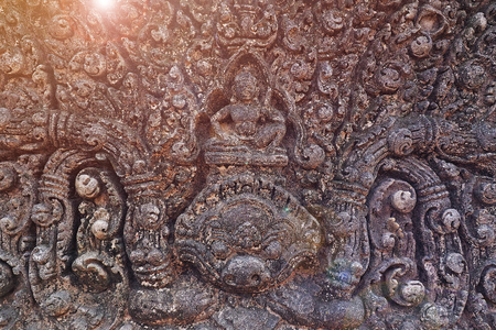 buddha stone carving at public Temple (Prasat Muang Tam) wall texture with sun light ray in Buriram thailandの写真素材