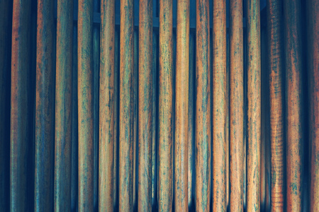 row of real wood pile on the beach fence in vintage background photographyの写真素材