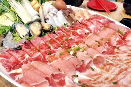 mix Pork slice and seafood platter set served on big white plate dish top with rich soya sauce for Shabu or Sukiyaki Japanese hot pot styleの写真素材