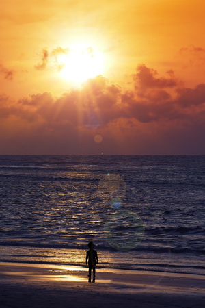 boy stand on the beach looking the sunsetの写真素材